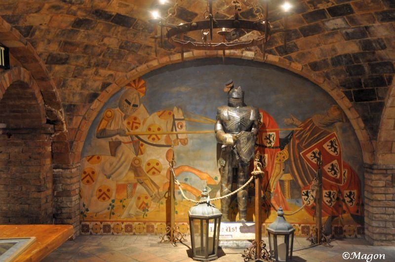 Castello Di Amorosa: доспехи рыцаря и фреска с гербами в подземном зале